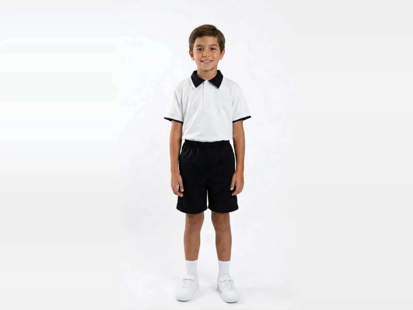 Niño con uniforme escolar: playera polo blanca con cuello negro y short negro